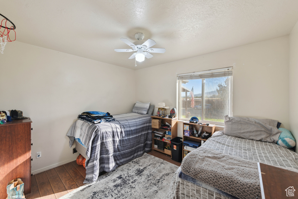 Bedroom featuring a textured ceiling, ceiling fan, and hardwood / wood-style flooring