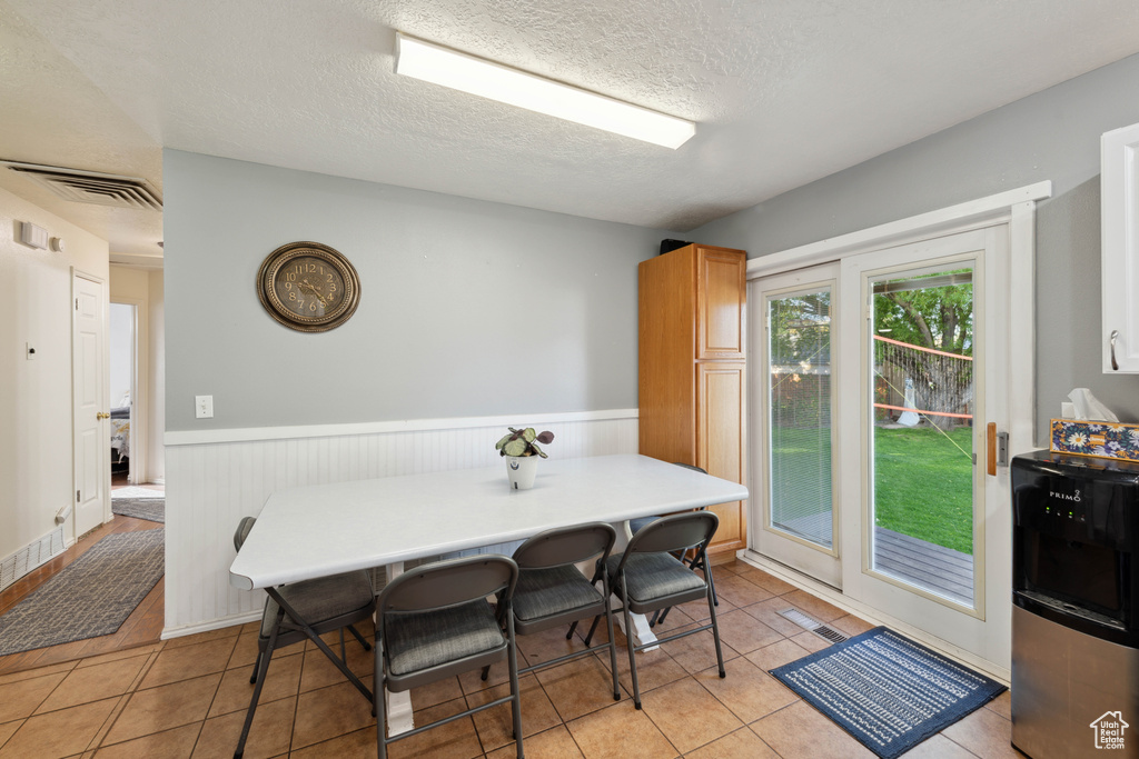 Tiled dining room with a textured ceiling