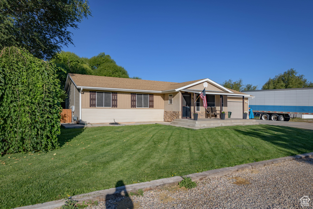 Ranch-style house featuring a front lawn and a patio area