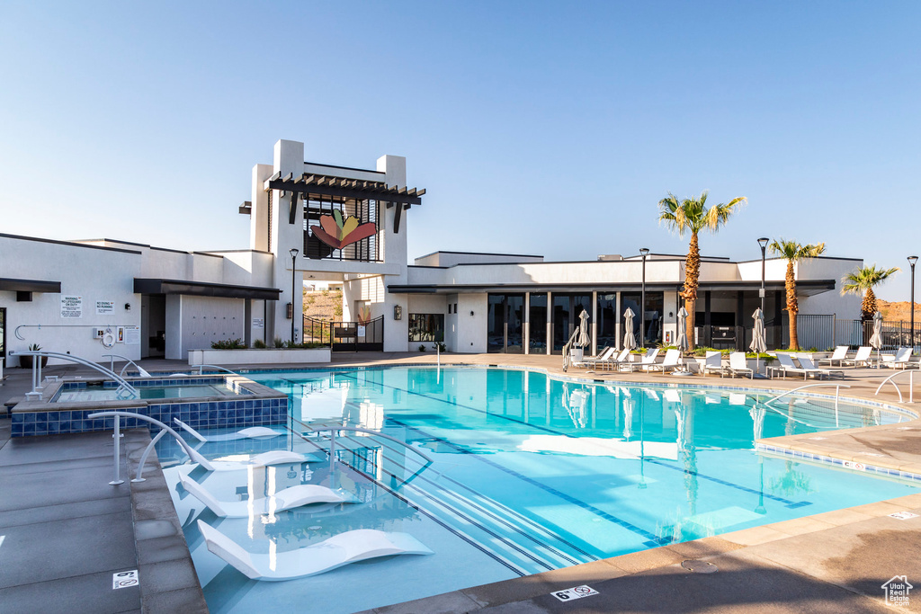 View of swimming pool featuring a community hot tub and a patio