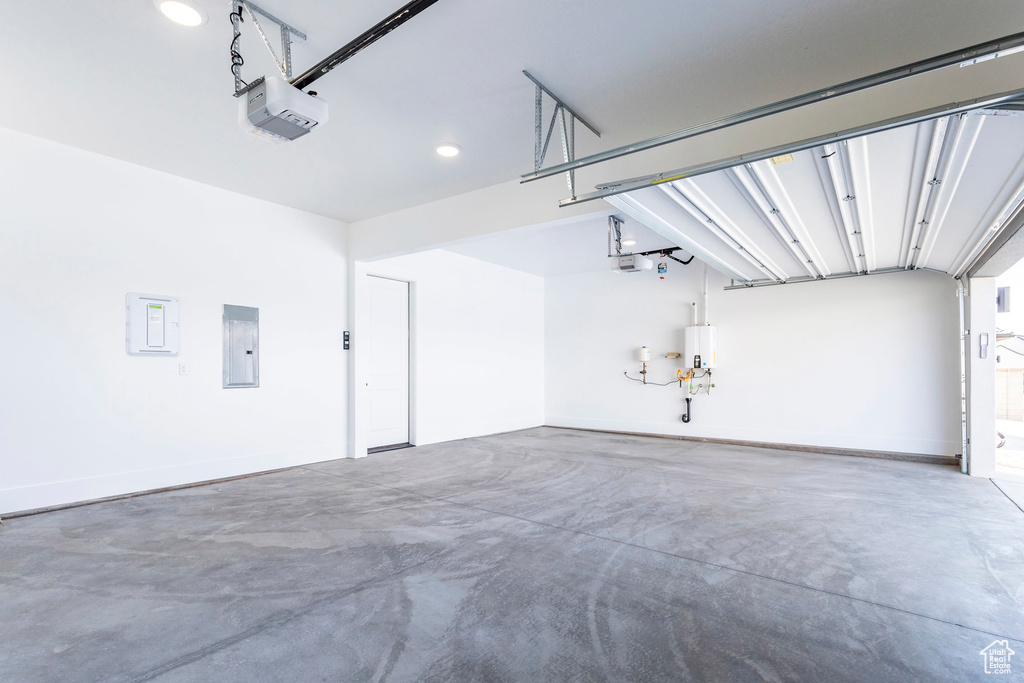 Garage with electric panel, a garage door opener, and water heater