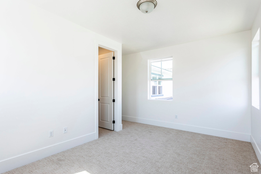 Unfurnished room featuring light carpet