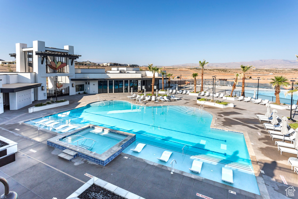 View of swimming pool featuring a patio, a mountain view, and a community hot tub