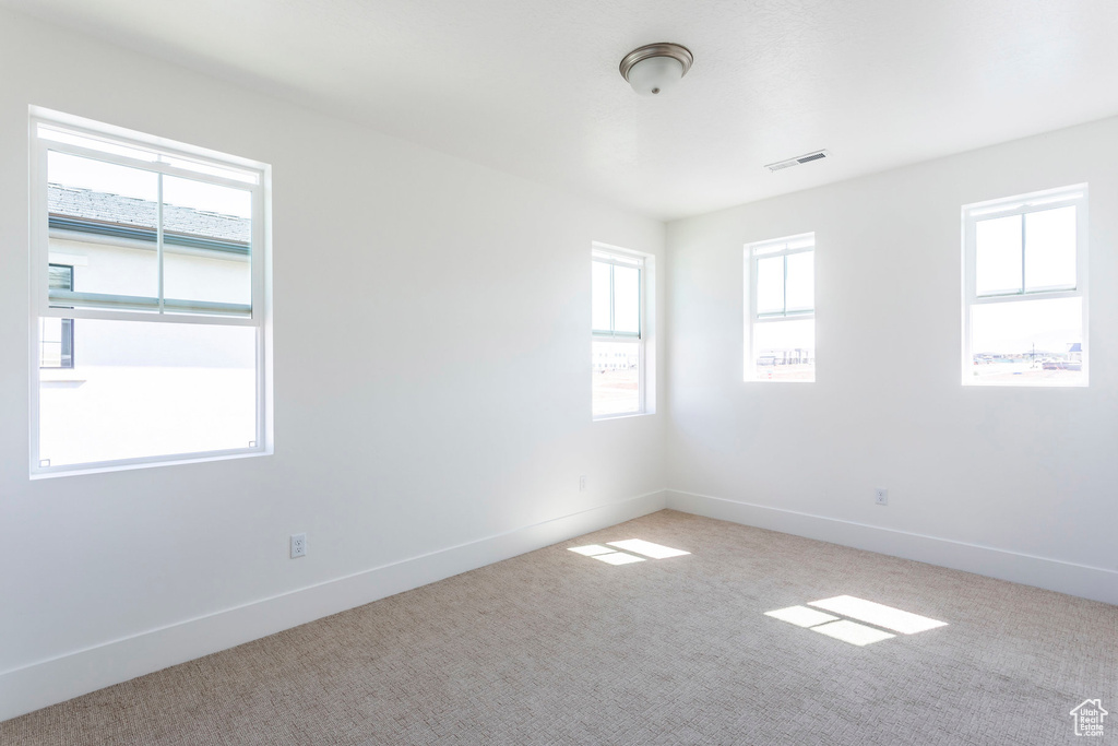 Carpeted empty room with a healthy amount of sunlight