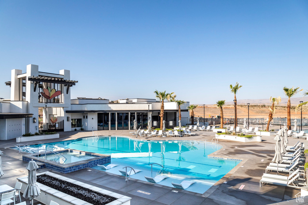 View of swimming pool featuring a community hot tub and a patio