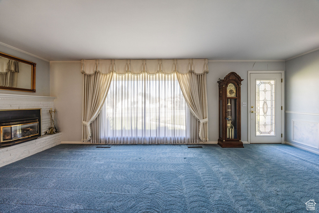 Unfurnished living room featuring crown molding and carpet flooring