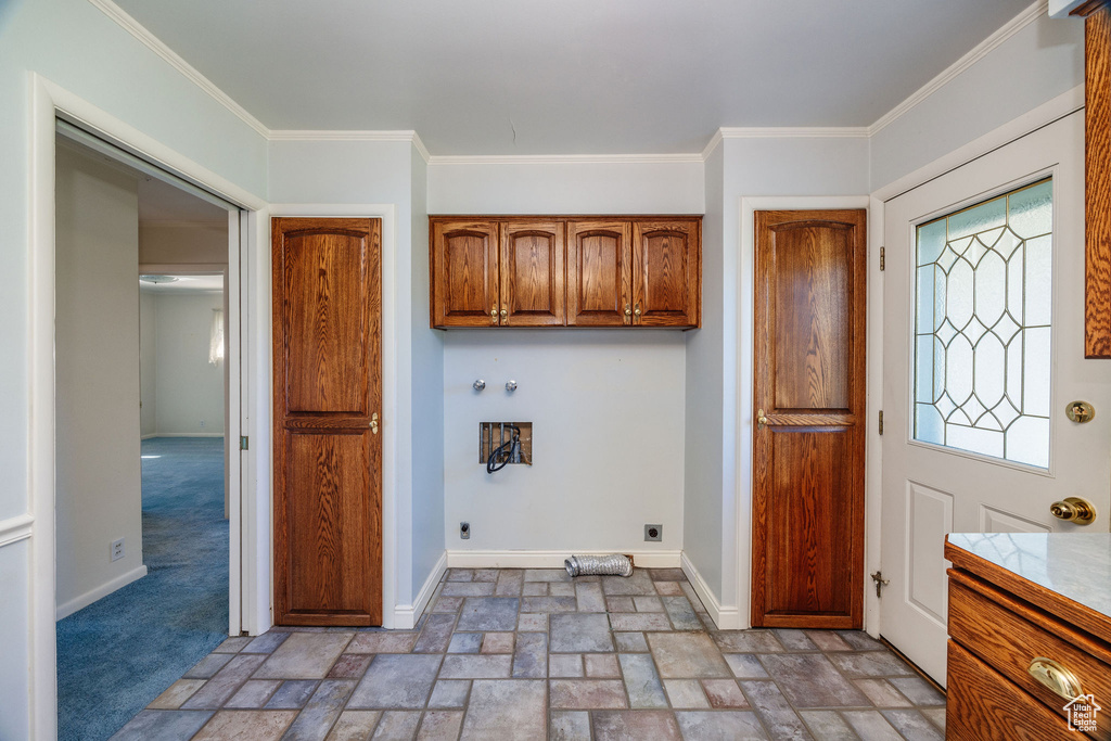 Washroom featuring hookup for a washing machine, cabinets, crown molding, and electric dryer hookup