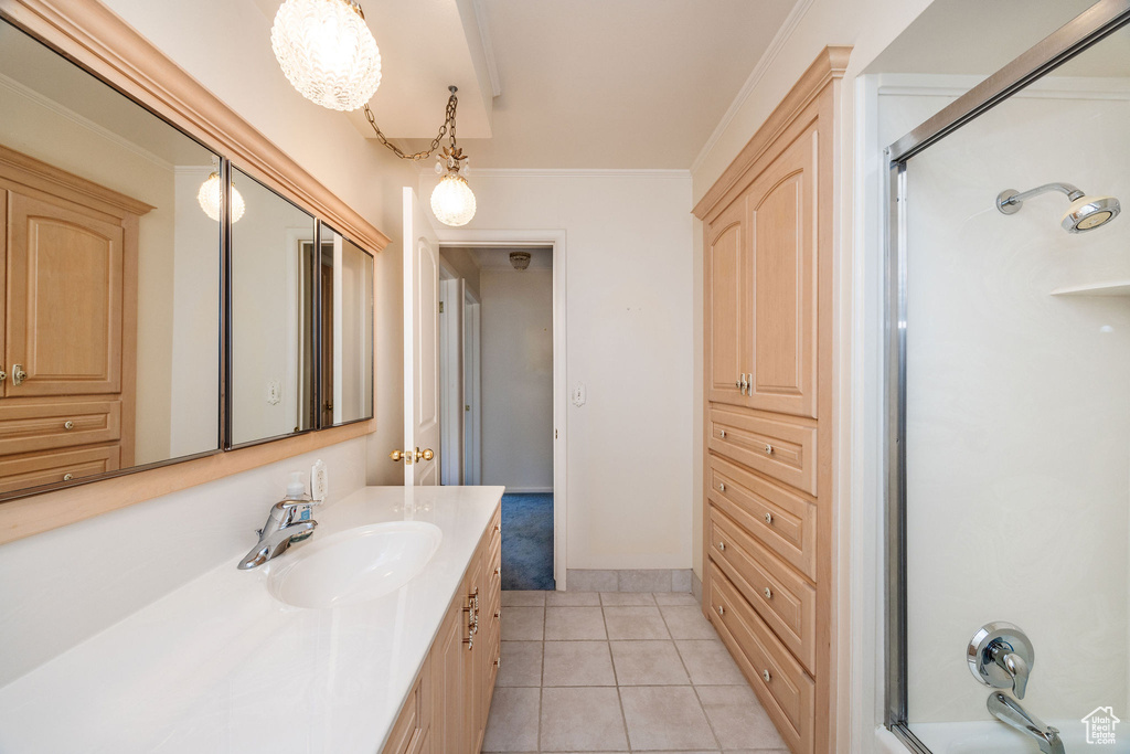 Bathroom with walk in shower, ornamental molding, tile patterned flooring, and vanity