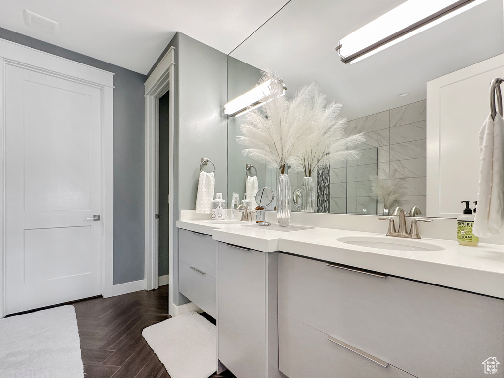 Bathroom with walk in shower, vanity, and parquet floors