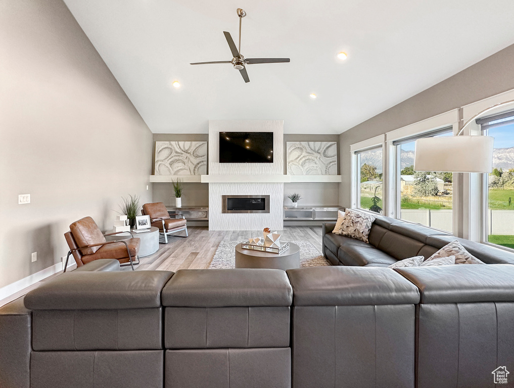 Living room featuring wood-type flooring, lofted ceiling, and a healthy amount of sunlight