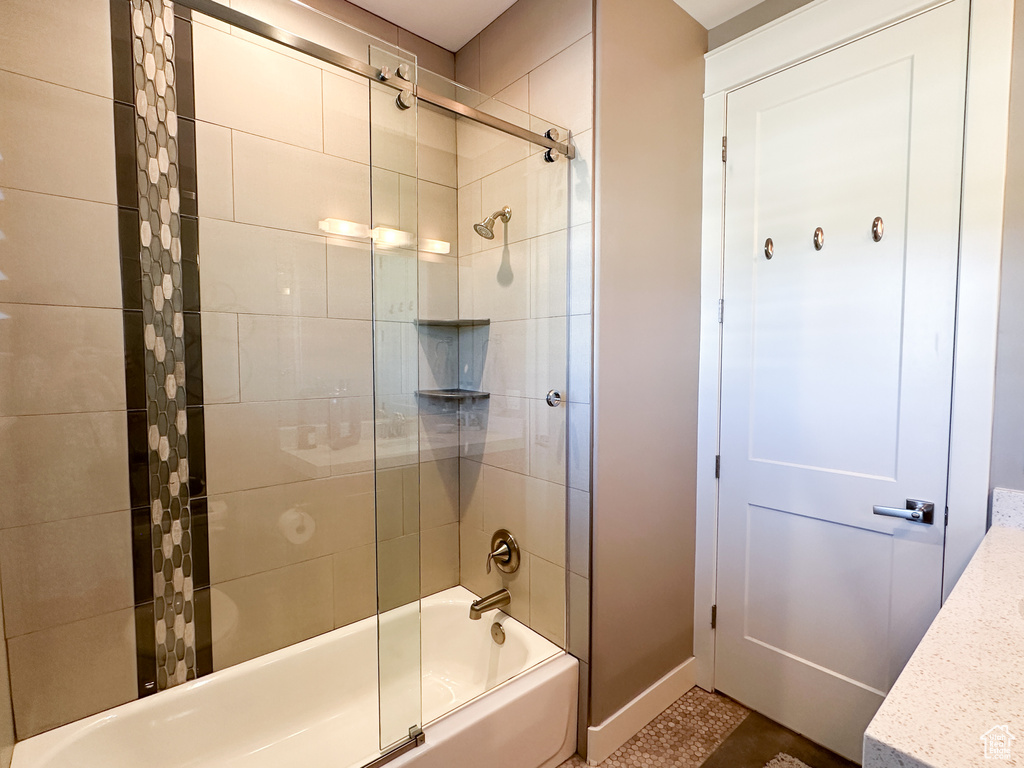 Bathroom with shower / bath combination with glass door and vanity