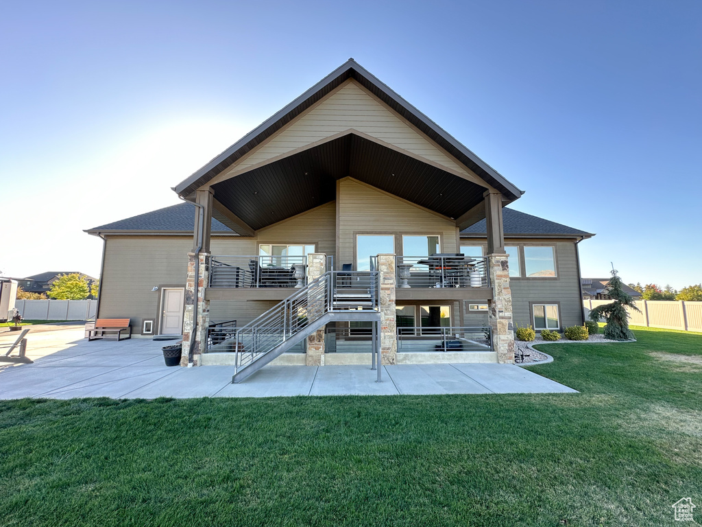 Rear view of house with a patio area, a deck, and a yard