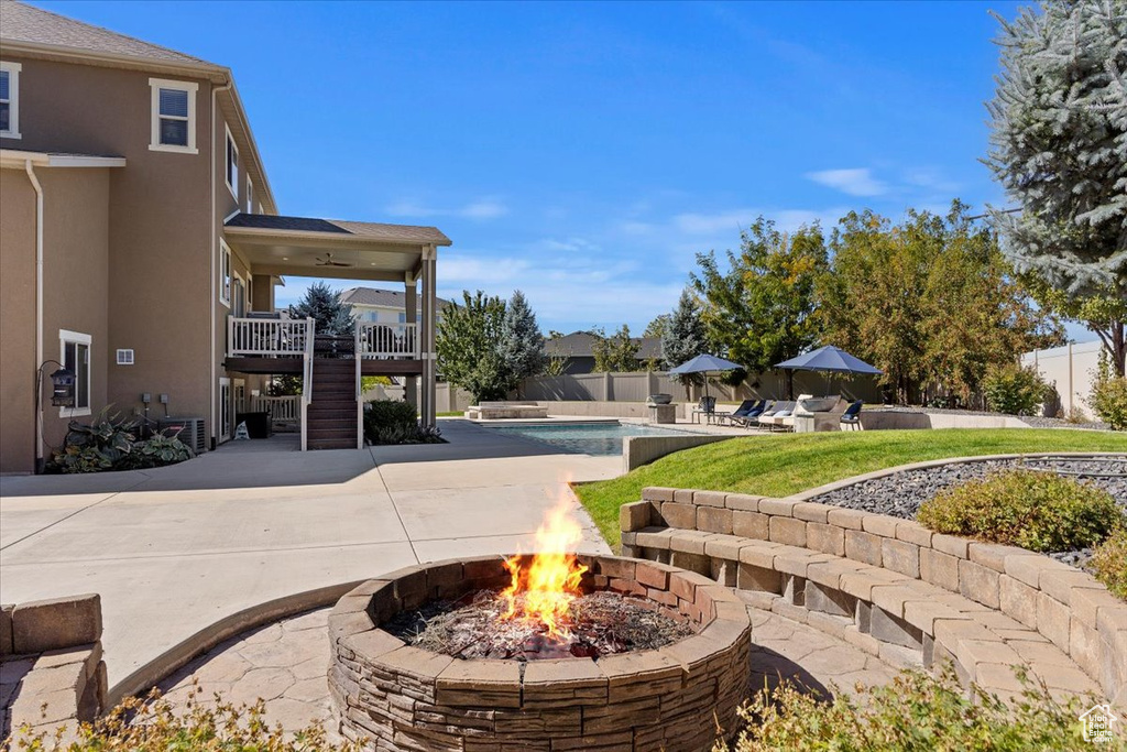 View of property\'s community with a swimming pool, a patio, and a fire pit