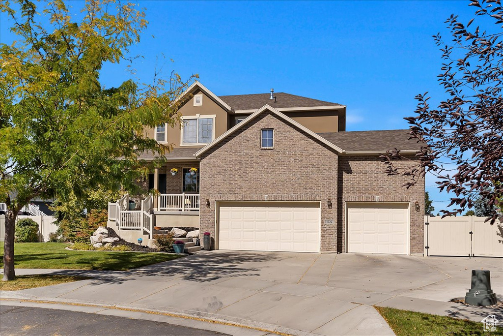 View of front of home with a garage, a front lawn, and a porch