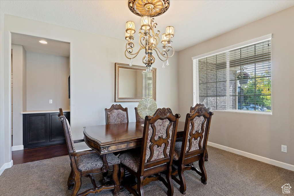 Dining space with dark carpet and a chandelier