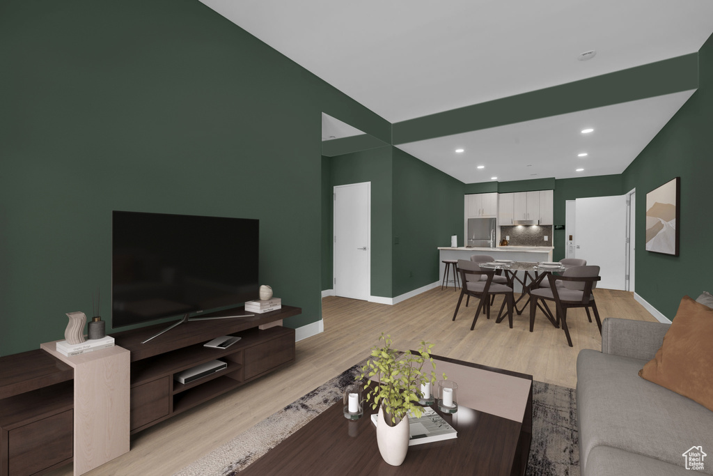 Living area with light wood finished floors, baseboards, and recessed lighting