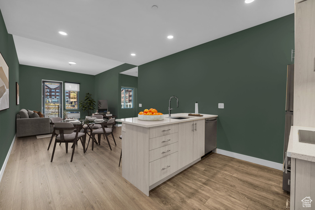 Kitchen featuring a sink, stainless steel dishwasher, modern cabinets, baseboards, and recessed lighting
