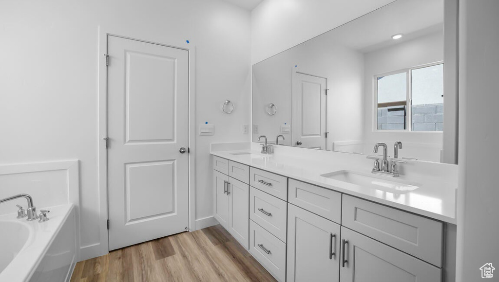 Bathroom featuring vanity, hardwood / wood-style floors, and a tub