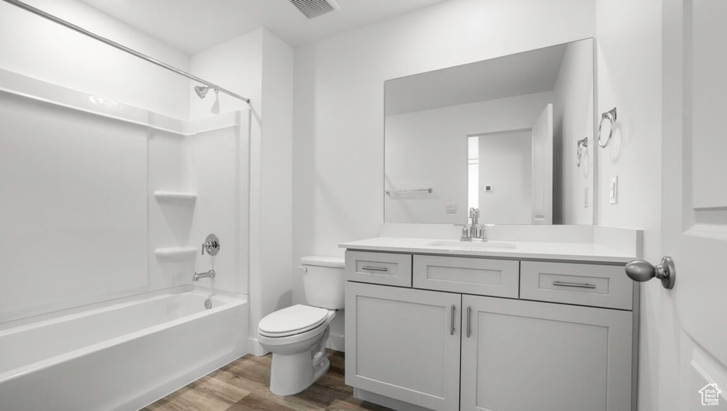 Full bathroom featuring tub / shower combination, hardwood / wood-style floors, vanity, and toilet