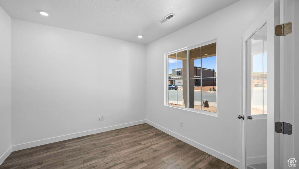 Unfurnished room with a healthy amount of sunlight and dark hardwood / wood-style flooring