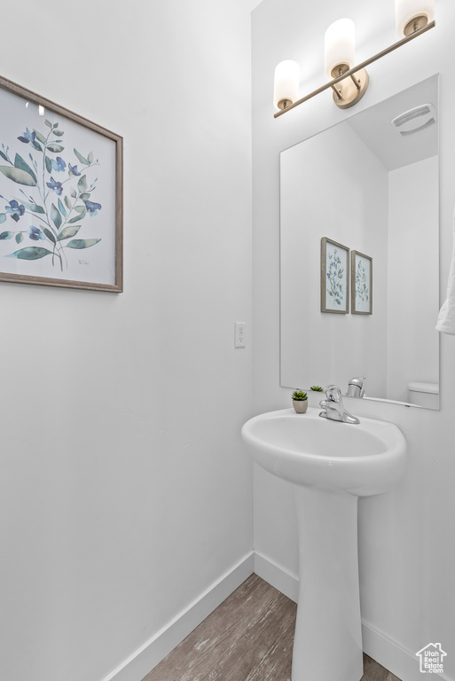 Bathroom with hardwood / wood-style flooring and sink