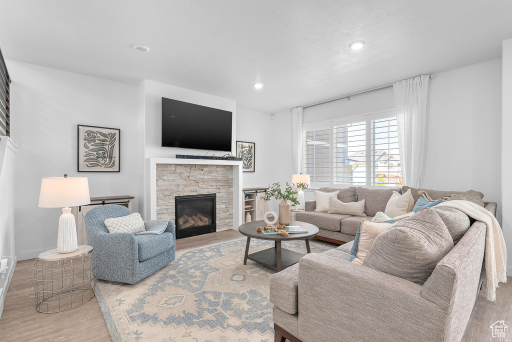 Living room featuring hardwood / wood-style floors and a stone fireplace