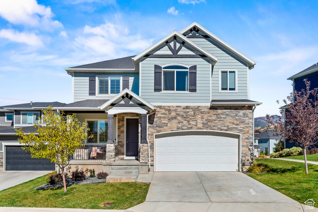 Craftsman house with a front yard and a garage