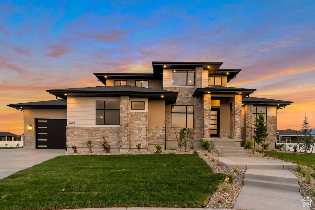 Prairie-style home featuring a lawn and a garage