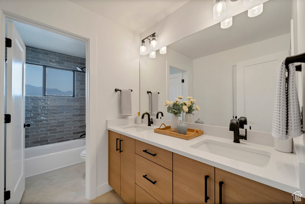 Full bathroom with vanity, toilet, and tiled shower / bath