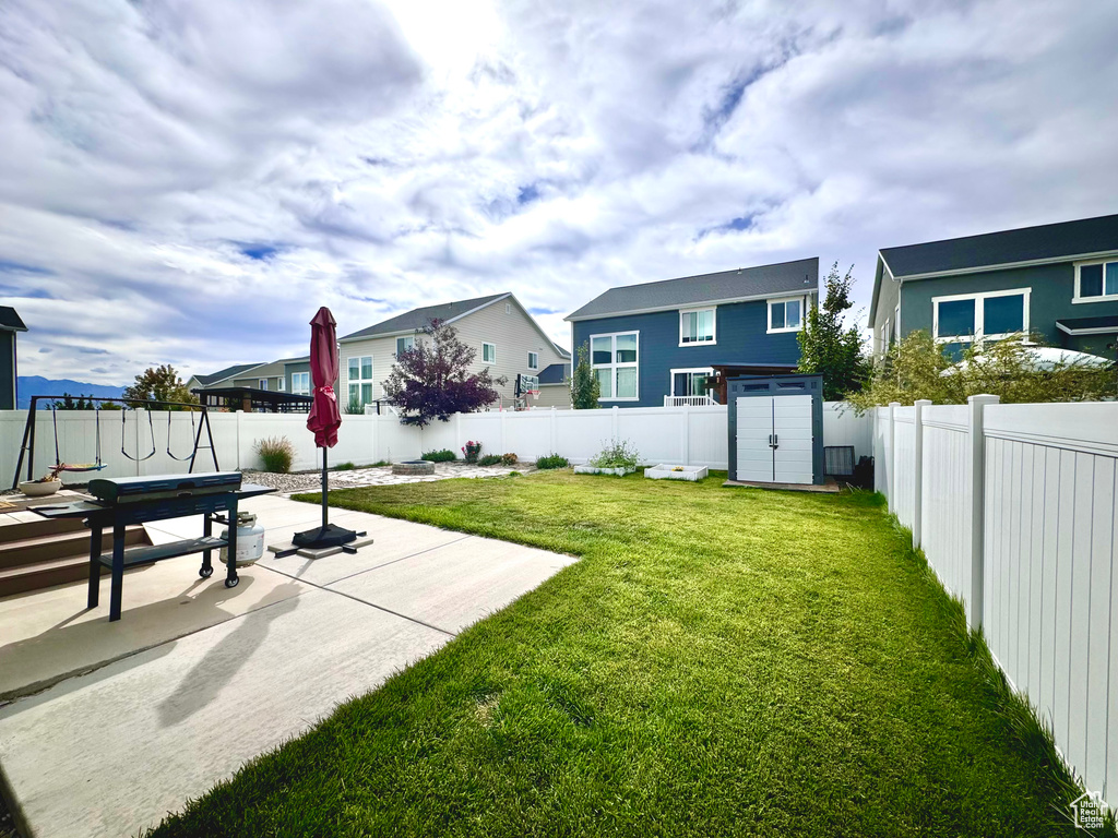 View of yard with a storage unit and a patio