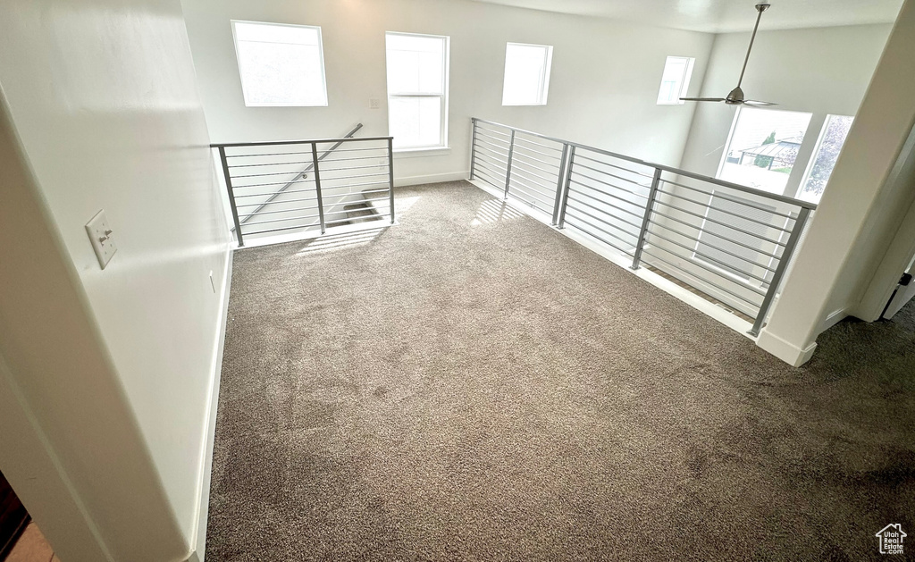 Interior space with carpet, a high ceiling, and ceiling fan