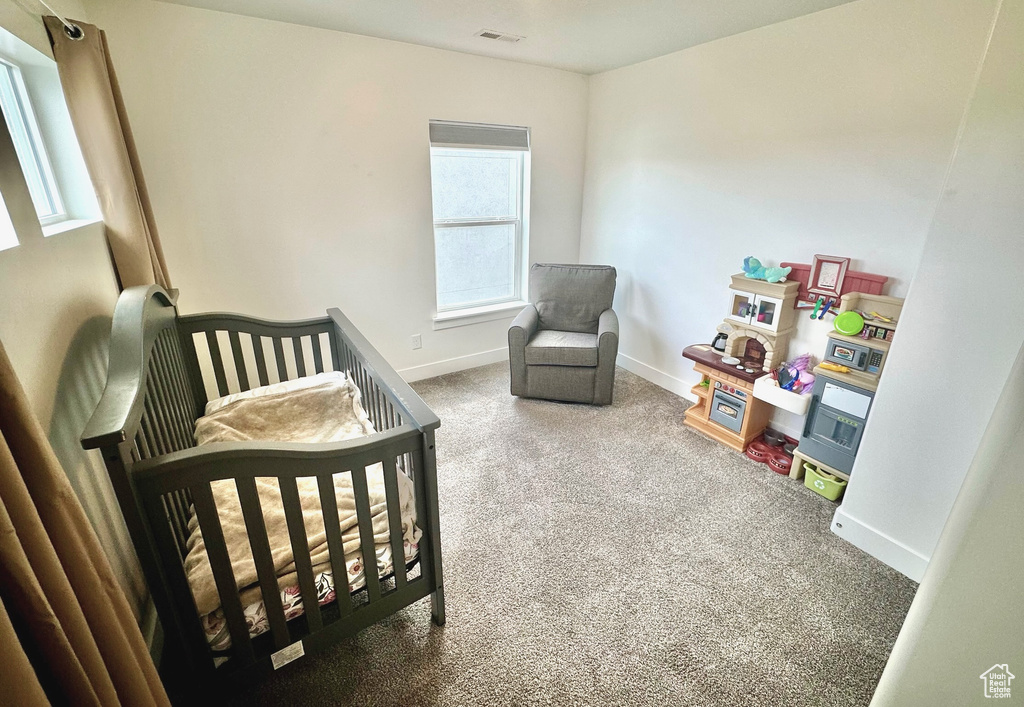 Bedroom with carpet and a nursery area