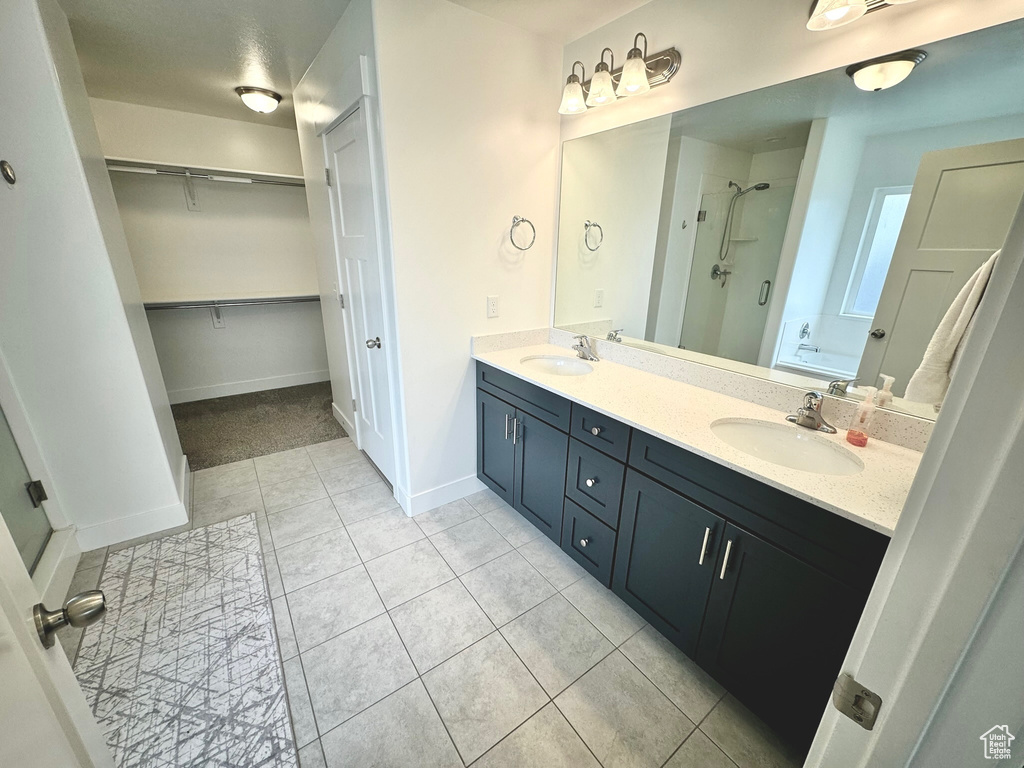 Bathroom featuring vanity, a shower with door, and tile patterned floors