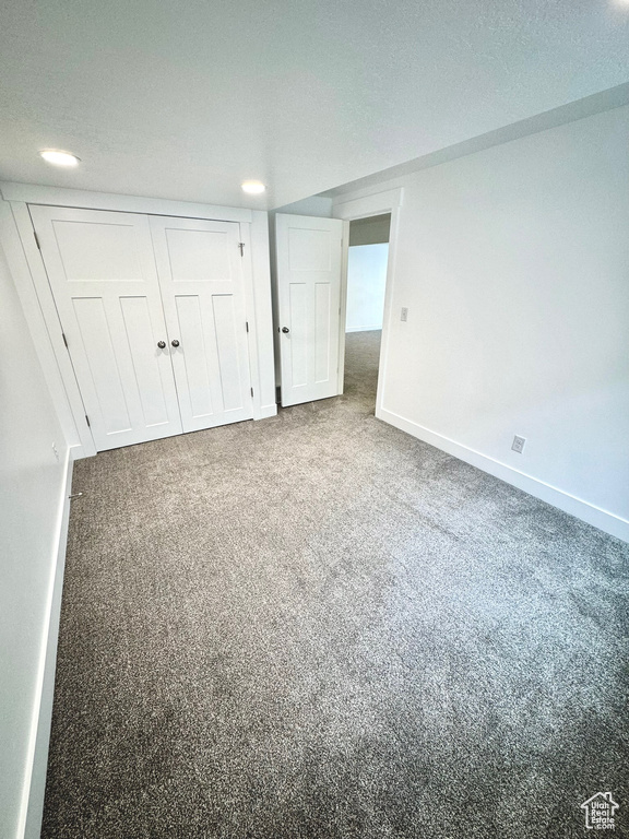 Interior space with carpet floors, a textured ceiling, and a closet