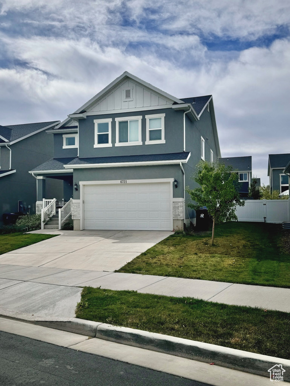 View of front of house with a front yard and a garage