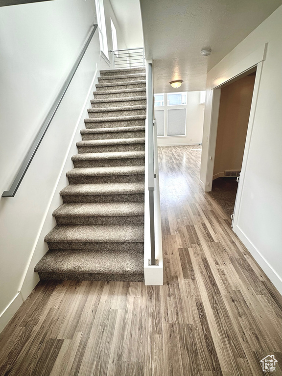 Stairway featuring wood-type flooring