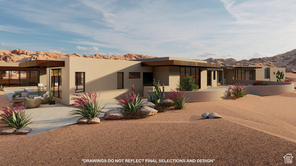 Pueblo revival-style home featuring a mountain view and a patio area