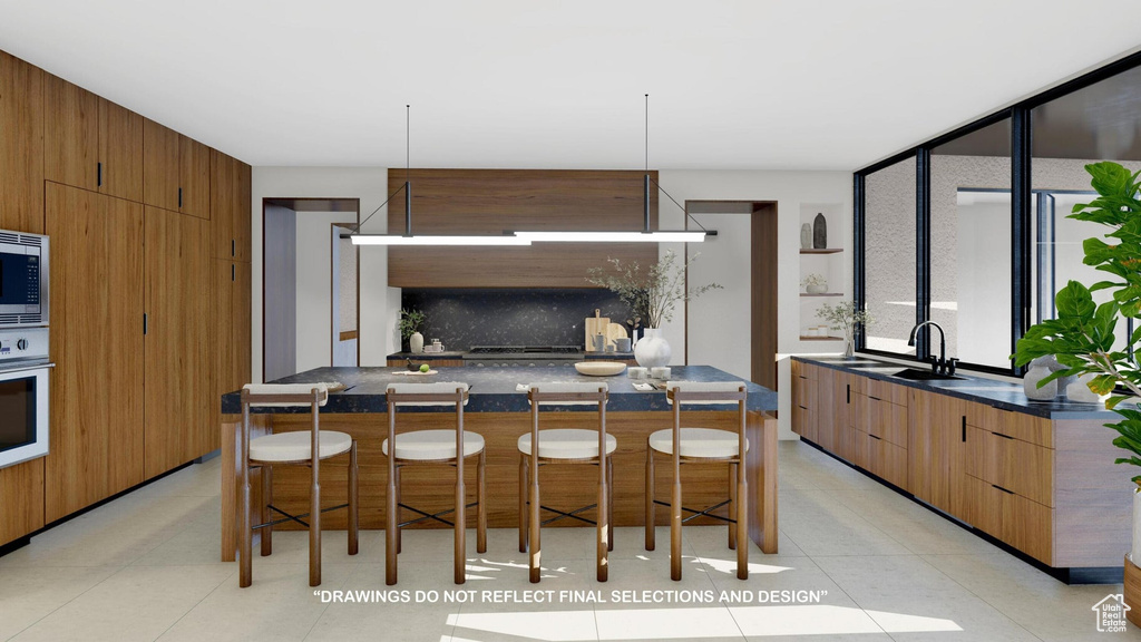 Kitchen featuring a kitchen bar, backsplash, sink, and a kitchen island