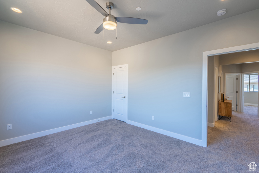 Spare room featuring ceiling fan and carpet
