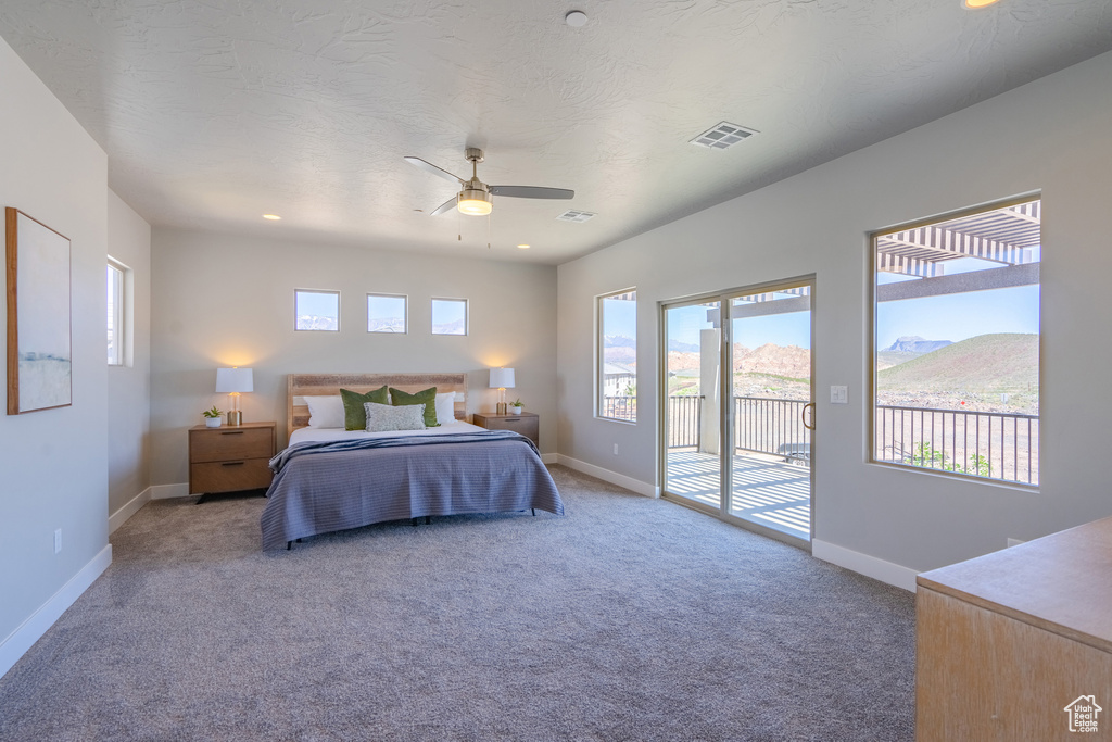 Carpeted bedroom with access to outside, a mountain view, and ceiling fan