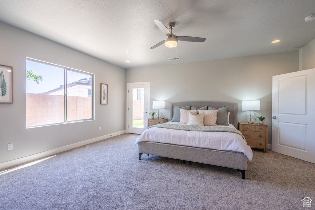 Carpeted bedroom featuring ceiling fan