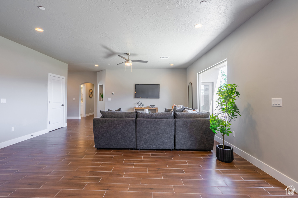 Living room featuring a textured ceiling, dark hardwood / wood-style floors, and ceiling fan