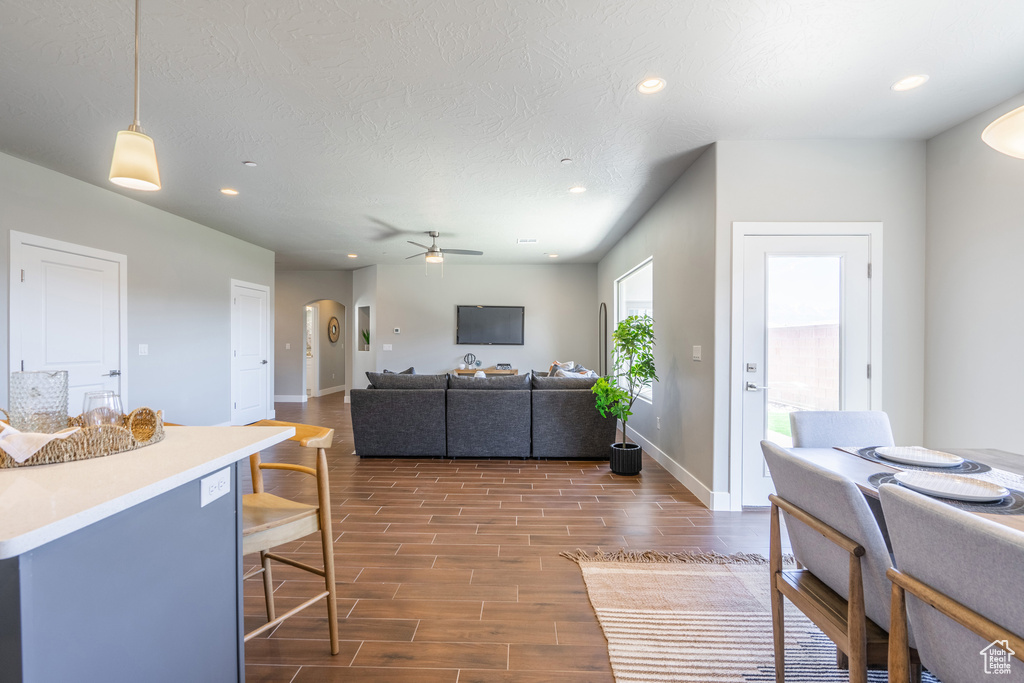 Living room featuring a textured ceiling, dark hardwood / wood-style floors, and ceiling fan