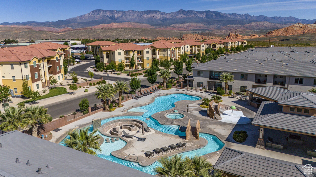 View of swimming pool with a hot tub, a patio area, and a mountain view