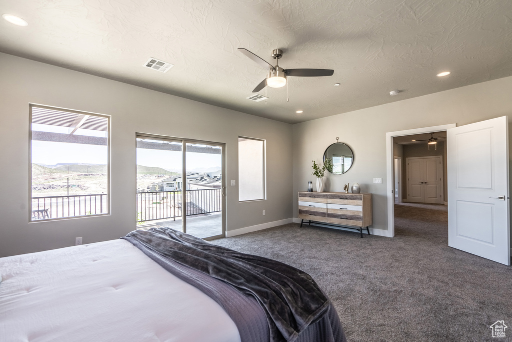 Bedroom with dark colored carpet, a mountain view, a textured ceiling, access to exterior, and ceiling fan