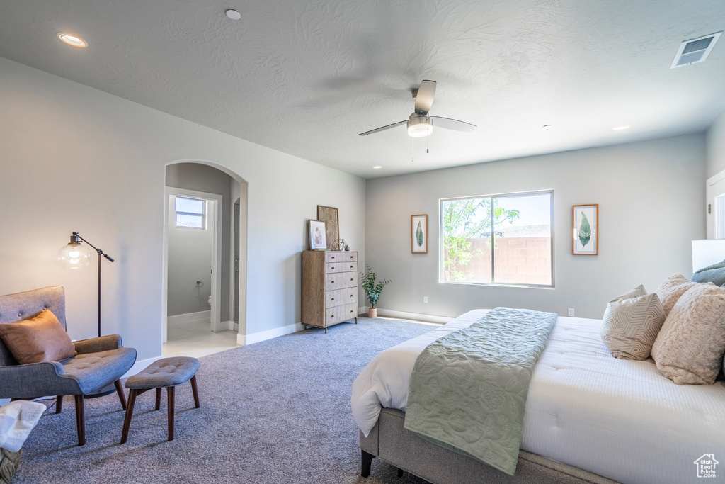 Bedroom featuring ceiling fan, light colored carpet, and a textured ceiling