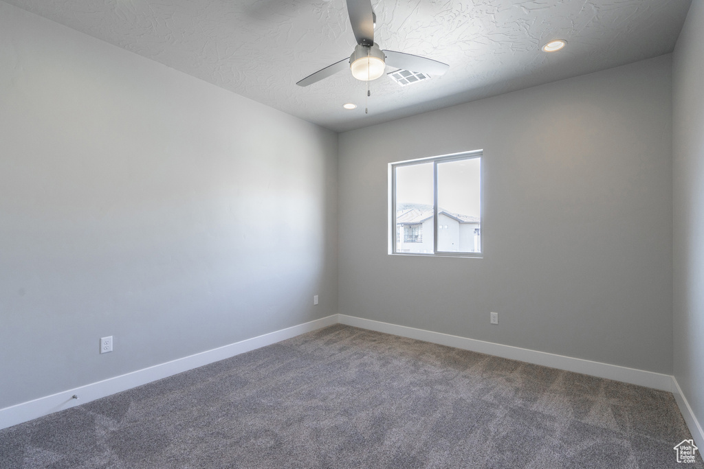 Unfurnished room featuring carpet floors, a textured ceiling, and ceiling fan