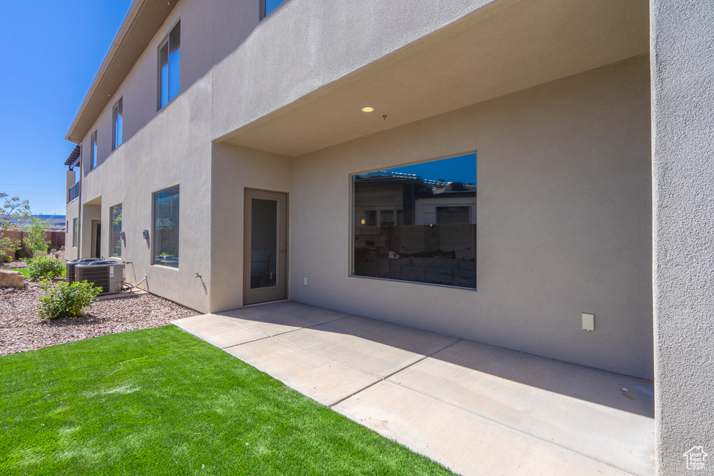 Rear view of house with a lawn, a patio area, and central air condition unit