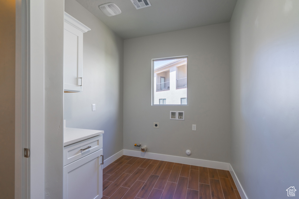 Clothes washing area featuring washer hookup, dark hardwood / wood-style flooring, hookup for an electric dryer, cabinets, and gas dryer hookup
