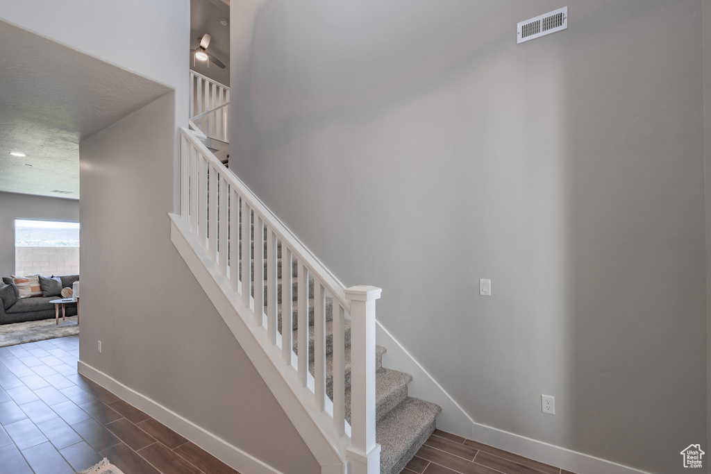 Stairs with a textured ceiling and hardwood / wood-style floors